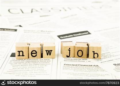 closeup new job wording on classifieds ads and newspaper, recruitment and employment concepts and ideas