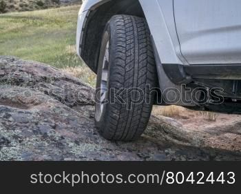 Closeup of 4x4 SUV car driving on a rocky trail
