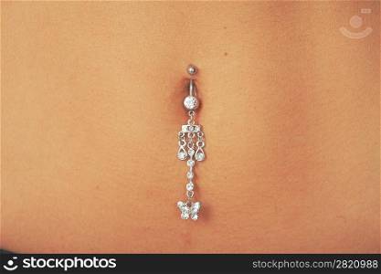 Closeup of a belly button pierced with jewelry