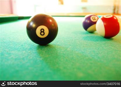 Closeup of a black Billiard Ball on green layout table