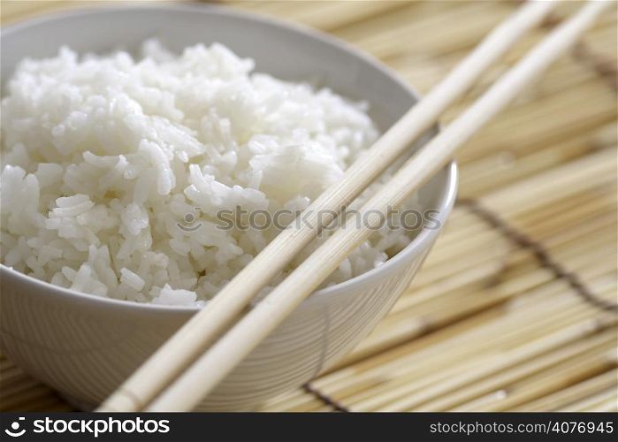 Closeup of a bowl of rice on bamboo