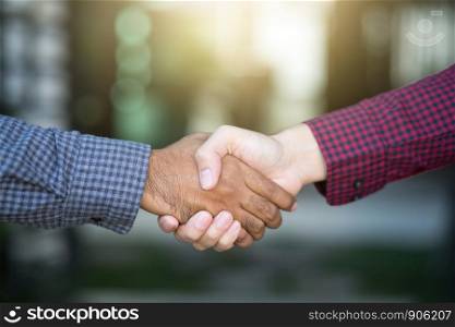 Closeup of a business hand shake between two colleagues Plaid shirt red and black