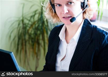 Closeup of a business woman with laptop and headset
