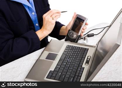 Closeup of a businesswoman transferring data from her PDA to her laptop.