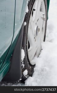 Closeup of a car wheel riding on snow.