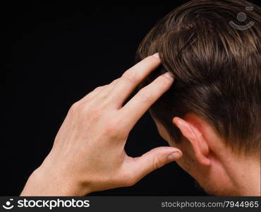 Closeup of a caucasian male thinking with one hand towards head isolated on black