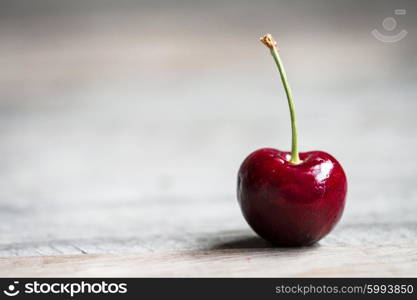 Closeup of a cherry on wooden background