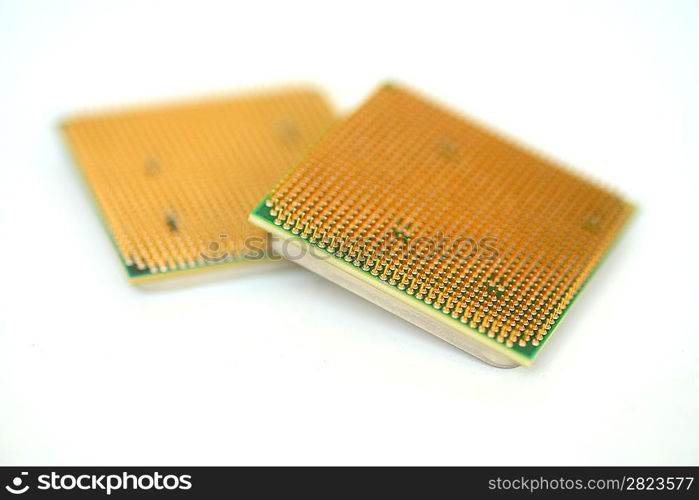 Closeup of a computer processor with golden pins over a white background