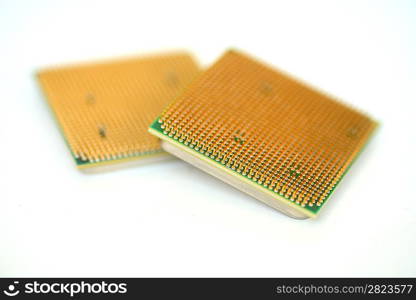 Closeup of a computer processor with golden pins over a white background