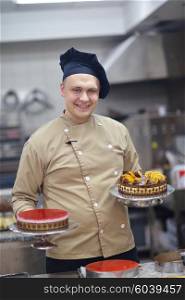 Closeup of a concentrated male pastry chef decorating dessert cake food in the kitchen