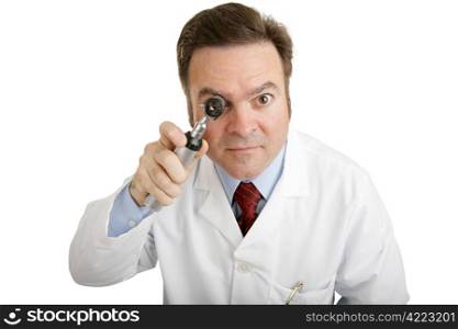 Closeup of a doctor peering into an otoscope directly toward the camera.