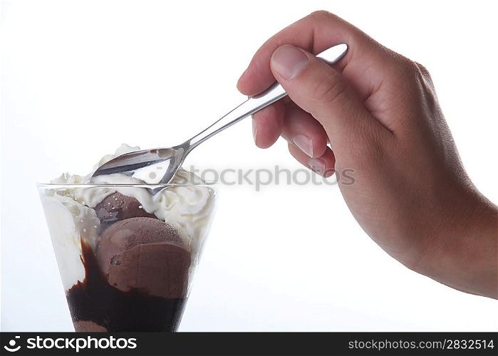 Closeup of a hand taking a spoonful of chocolate ice cream