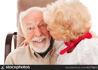 Closeup of a handsome senior man getting a kiss from his beautiful wife.