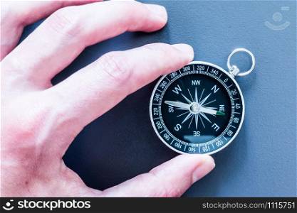 Closeup of a mans hand holding a compass in his hand. Concept for business, innovation