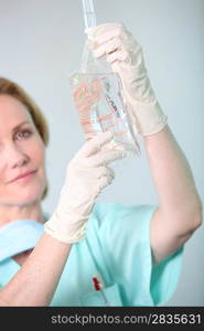 Closeup of a nurse in scrubs administering drip