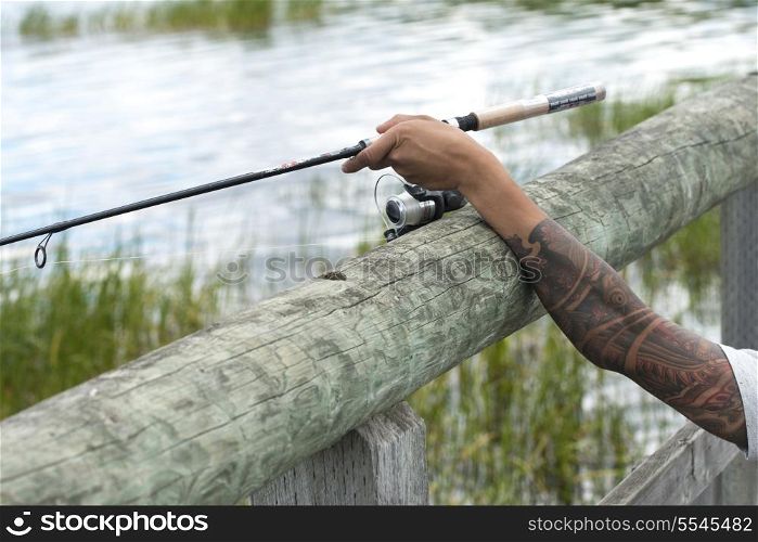 Closeup of a person&rsquo;s arm holding a fishing rod, Riding Mountain National Park, Manitoba, Canada