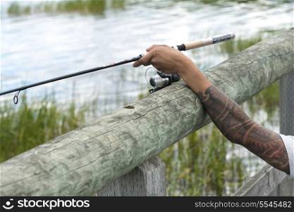 Closeup of a person&rsquo;s arm holding a fishing rod, Riding Mountain National Park, Manitoba, Canada