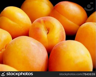 Closeup of a pile of fresh clean apricots in a black box