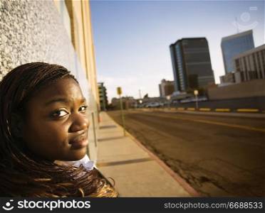 Closeup of a pretty African American woman leaning on a building