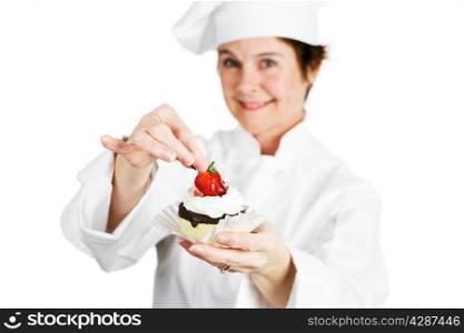 Closeup of a pretty baker holding a delicious strawberry chocolate cheesecake tart. Shallow depth of field with focus on the strawberry and the tart.