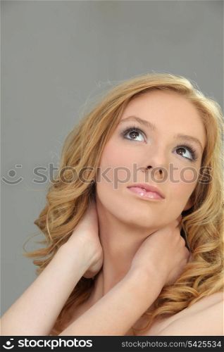 Closeup of a pretty woman holding her neck
