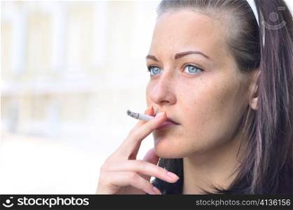 closeup of a pretty woman smoking at the street