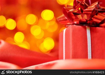 closeup of a red gift box with blurred lights on background