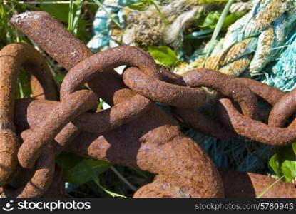 closeup of a rusty chain with a rope in the background