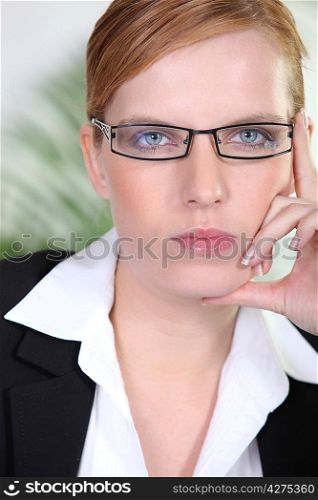Closeup of a serious businesswoman in trendy glasses
