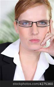 Closeup of a serious businesswoman in trendy glasses