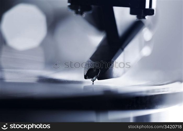 Closeup of a turntable stylus playing on a vinyl LP record.
