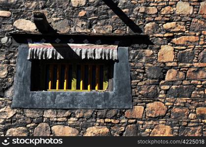 Closeup of a typical Tibetan window and rock wall