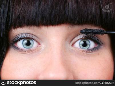 closeup of a woman applying mascara