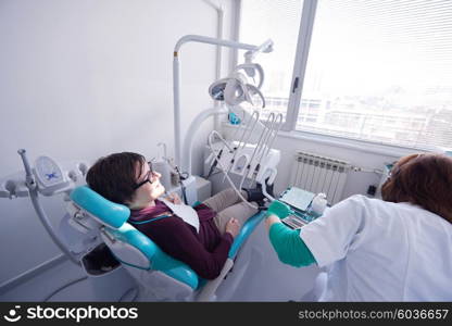 Closeup of a woman patient at the dentist waiting to be checked up with the woman doctor in the background