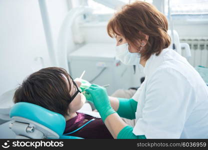 Closeup of a woman patient at the dentist waiting to be checked up with the woman doctor in the background