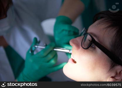 Closeup of a woman patient at the dentist waiting to be checked up with the woman doctor in the background