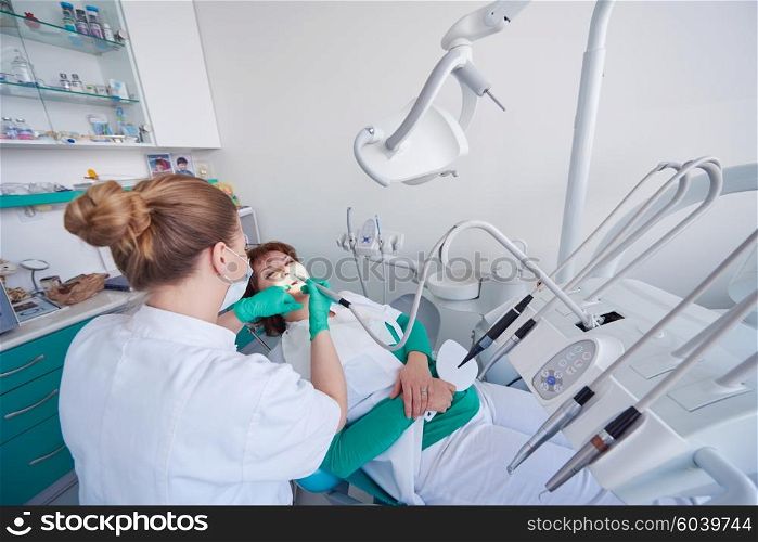 Closeup of a woman patient at the dentist waiting to be checked up with the woman doctor in the background