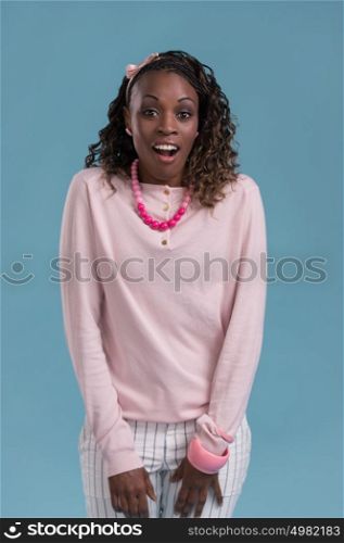 Closeup of a young African woman looking surprised on blue background