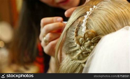 Closeup of a young bride applying cosmetics around her eye