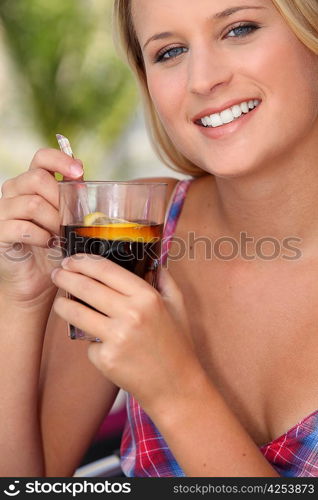 Closeup of a young woman enjoying a refreshing drink on a warm summer&acute;s day