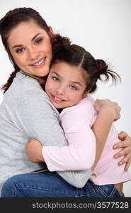 Closeup of a young woman hugging a little girl
