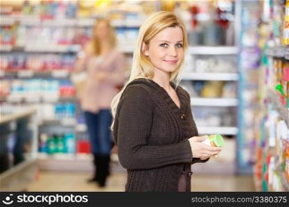 Closeup of a young woman smiling while shopping in the supermarket