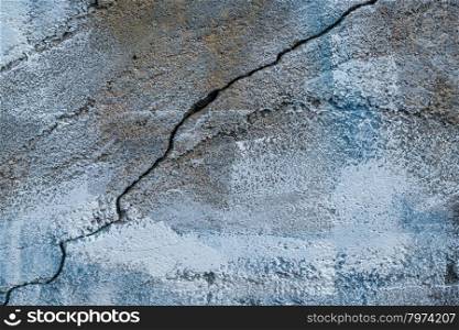 closeup of aging, grunge concrete wall texture with blue paint, cracks and chips