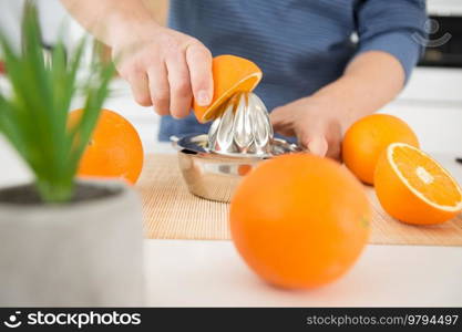 closeup of an metallic juice squeezer and oranges