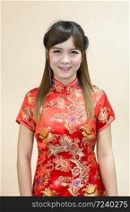 Closeup of asian woman greeting in traditional Chinese or cheongsam in chinese new year celebration in red golden style