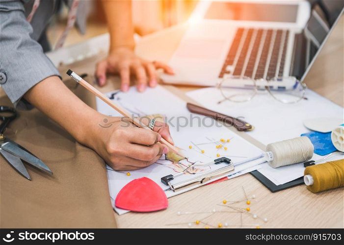 Closeup of attractive female fashion designer hand working in home office workshop. Stylish fashionista woman creating new cloth design collection. Tailoring and sewing People lifestyle and occupation