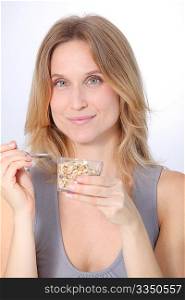 Closeup of beautiful blond woman eating cereals