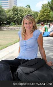 Closeup of beautiful blond woman sitting in a park