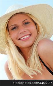 Closeup of beautiful blond woman wearing hat at the beach