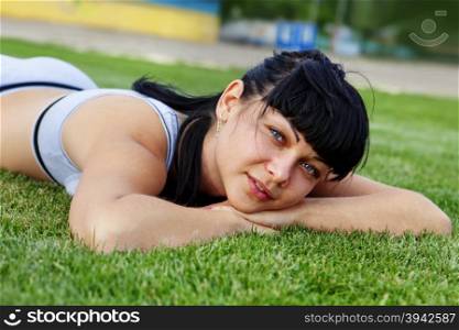 closeup of beautiful dreamy woman face that lies on grass